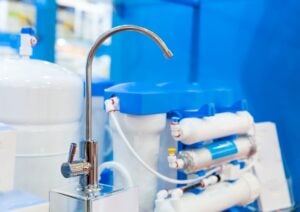 Under-sink reverse osmosis system connected to a chrome faucet for filtered drinking water